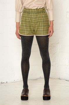 The sports luxe trend is given a smart update with these gorgeous check shorts. They’re made from roll-end soft wool blends that help cut down on fashion waste. The shorts have an elasticated waist for a comfortable fit and are finished with contrasting piping around the leg.The Dolly shorts are available in two colors: brown and green. The neutral tones make them easy to pair with other garments, and they can easily be dressed up with a silky blouse or long-sleeve jersey. Only 30 pieces of each color will be produced. Roll End Wool Blend (60% Wool / 40% Polyester) exclusive of trim Made in England Dry Clean Fashion Waste, Office Fits, Pants Model, Placement Print, Water Waste, Brown And Green, Organic Ring, Silky Blouse, Sports Luxe