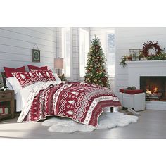 a bedroom decorated for christmas with red and white bedding, fireplace and holiday decorations