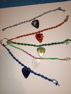 five different colored string bracelets with hearts on them