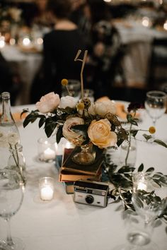 an arrangement of flowers and candles on a table