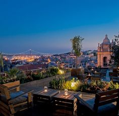 an outdoor dining area overlooking the city at night