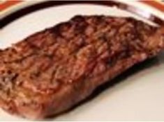 a piece of steak sitting on top of a white plate