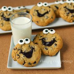 chocolate chip cookies with eyes and googly eyes next to a glass of milk on a plate