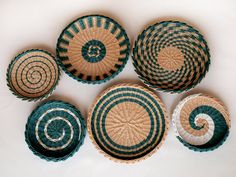 four baskets with different designs on them sitting next to each other in the shape of spirals