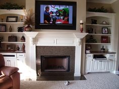 a flat screen tv mounted above a fireplace in a living room