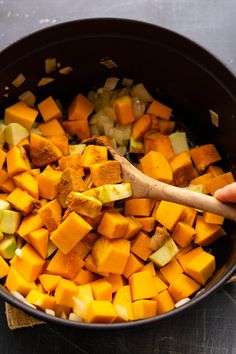 the food is being cooked and ready to be put in the pot with the wooden spoon