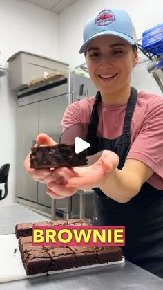 a woman holding a piece of brownie in her hands