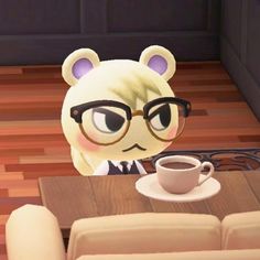 an animal with glasses sitting at a table in front of a cup and saucer