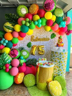 a table topped with lots of fruit and balloons