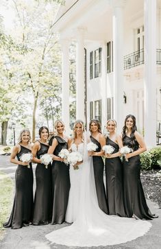 a group of women standing next to each other in front of a white building with columns