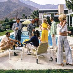 a group of people standing and sitting around a pool