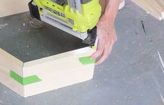 a person using a circular saw to cut wood planks with a jig attachment