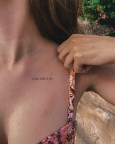 a woman with a small tattoo on her chest holding onto a piece of paper that says, you do not know