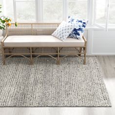 a living room with white walls and wooden furniture on top of a gray area rug