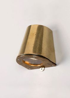 a gold colored wall light on a white background