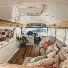 the inside of a camper with couches and pillows