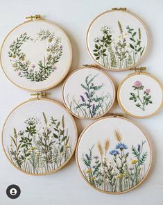 four embroidered flowers are shown in the hoop