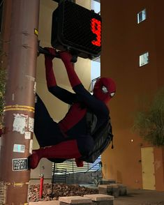 a spider man hanging upside down from a traffic light