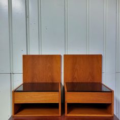 two wooden nightstands sitting side by side on top of a table