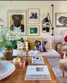 a living room filled with lots of furniture and pictures on the wall above it's coffee table