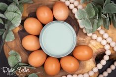 eggs and milk in a bowl on a wooden table with green leaves around the bowl