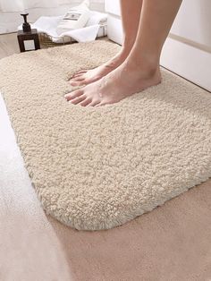 a person standing on top of a white rug with their feet propped up in the floor