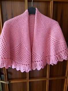 a pink sweater hanging on a wooden rack