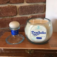 a candle sitting on top of a wooden box next to a bottle of donutjuto