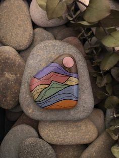 a painted rock sitting on top of some rocks