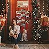 a woman sitting on the floor in front of a store with christmas decorations and presents