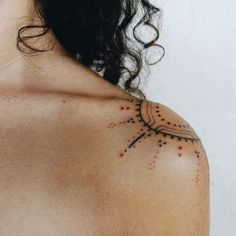 the back of a woman's shoulder with dots and lines on her left arm