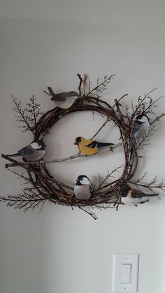 a bunch of birds sitting on top of a twig wreath hanging on the wall