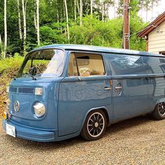 an old blue van parked in front of a house