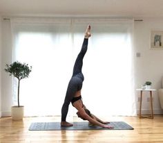 a woman in a yoga pose on a mat with her hands up to the ceiling