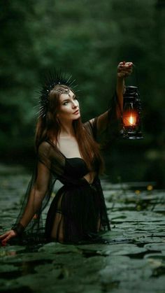 a woman holding a lantern in the water