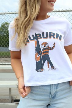 BEST SELLER! Gear up for game day in our favorite mom crop tee! The soft wash and exclusive design make this tee an absolute must-have for cheering on the Auburn Tigers this season! Auburn Aubie Flag Mom Crop Tee Officially licensed Designed by Scarlet & Gold TTS; our model is wearing a small Slight crop; hits at the waist Alternative Apparel brand tee Auburn gameday tee War Eagle tee Collegiate T-shirt With Sublimation Print For Game Day, Collegiate Graphic Print Top For Game Day, Game Day Sports Fan Short Sleeve Tops, School Spirit T-shirt For Game Day, Relaxed Fit, Game Day Sports Fan Top With Short Sleeves, Sports Fan Gear Short Sleeve Tops, Fan Apparel Tops For Football Season, Collegiate Relaxed Fit Tops For Football Season, Short Sleeve Tops For Game Day With School Spirit