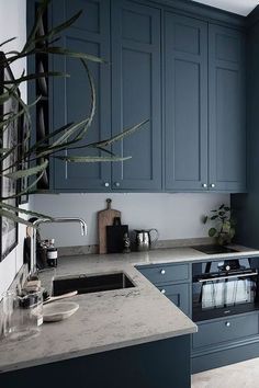 a kitchen with blue cabinets and marble counter tops