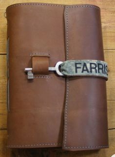 a brown leather journal with the word farris written on it and a metal lock