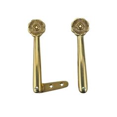 two brass door handles with flower decorations on each side and one has a hole in the middle