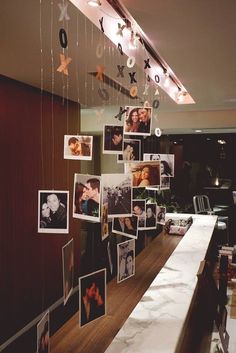 a long table with pictures hanging from it's ceiling and lights on the wall