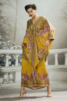 Mustard yellow kaftan tunic with floral print and shell tuck at the neckline. - Aza Fashions Eid Long Sleeve Printed Kaftan, Bohemian Floral Print Kaftan For Eid, Printed Kaftan For Eid, Festive Kaftan With Printed Motifs For Vacation, Floral Print Kaftan For Eid At The Beach, Floral Print Kaftan For Eid Vacation, Festive Yellow Kaftan With Printed Motifs, Floral Print Kaftan For Beach And Eid, Eid Floral Print Kaftan For Beach