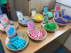 baskets filled with different colored plastic objects on top of a table