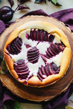 a pie with sliced beets and yogurt on top sits on a wooden platter