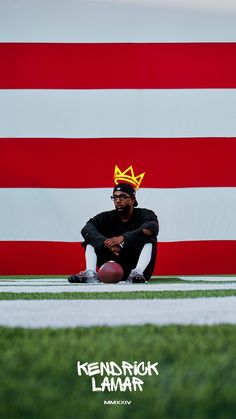 a man sitting on the ground in front of an american flag with a crown on his head