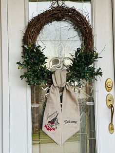 a door with a wreath and welcome sign hanging on it's front door handle