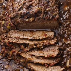 some meat is being cooked in a pan with brown gravy on the side