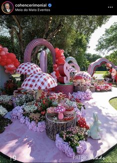 an elaborate garden with balloons and flowers on the ground, in front of a large number