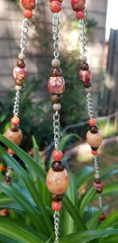 a long beaded necklace is hanging from a plant