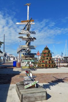 a wooden sign post with many different signs on it