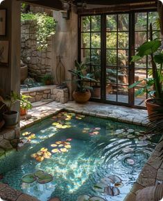 an indoor pool with water lilies and plants in the center, surrounded by stone walls